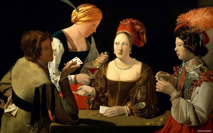 Four people playing cards at a table
