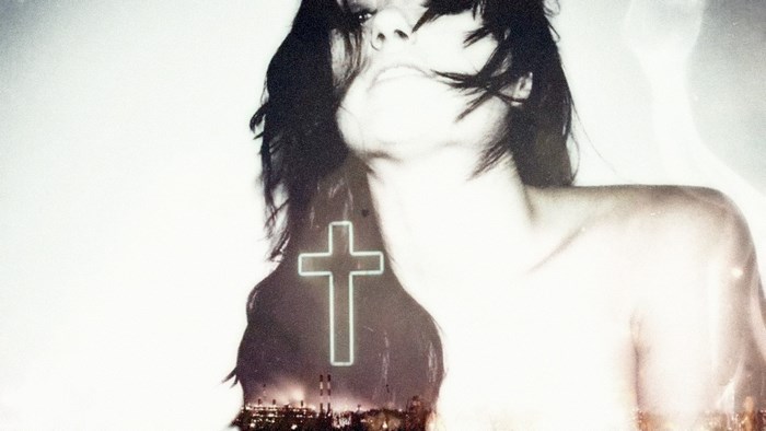 Double exposure of a woman and a neon cross over a city