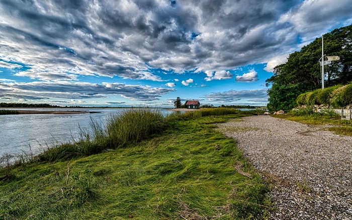 House by the water under a cloudy sky