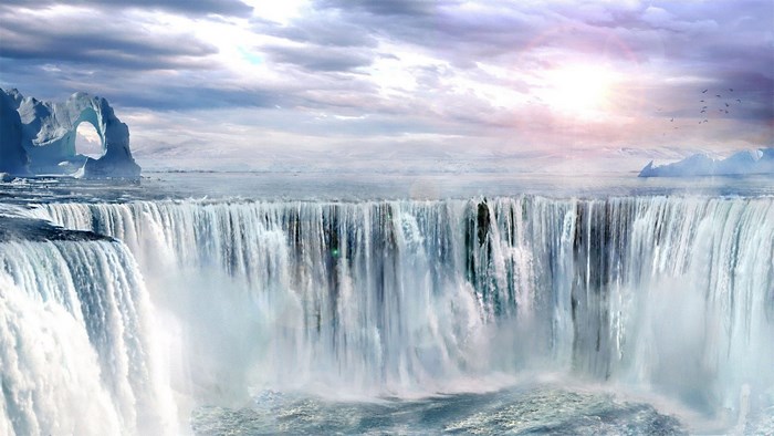 Frozen waterfall with ice arch and mountains