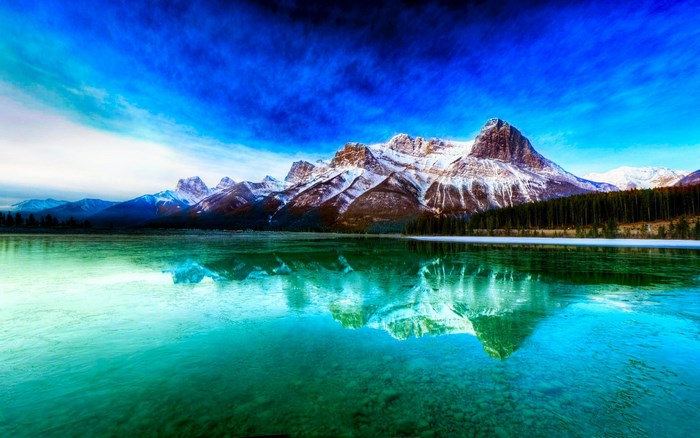 Snow-capped mountains reflected in a turquoise lake
