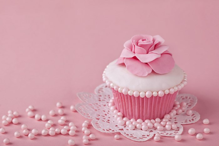 Pink cupcake with rose decoration and pearls