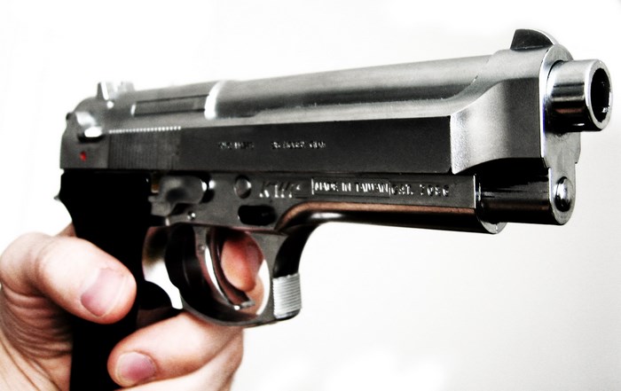 Hand holding a silver pistol