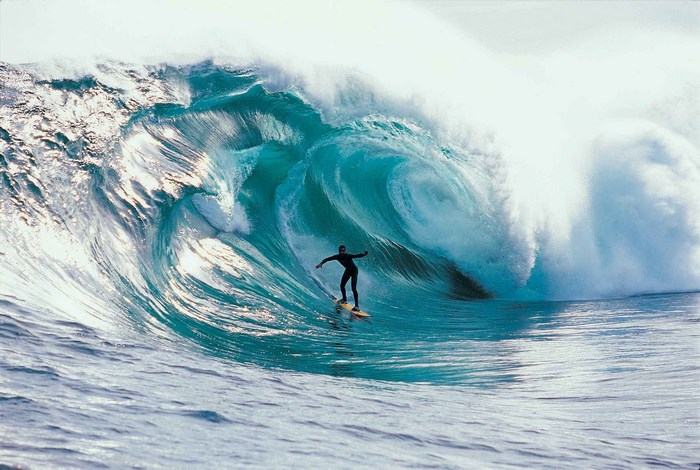 Surfer riding a massive wave