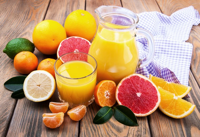 Citrus fruits and juice in a pitcher and glass