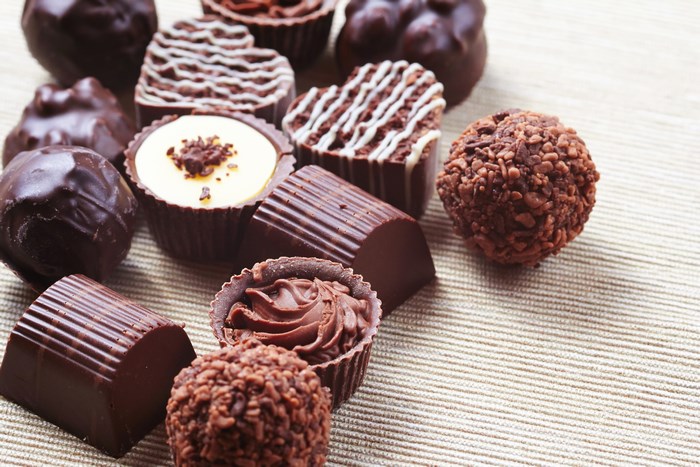 Assortment of gourmet chocolates on a textured surface