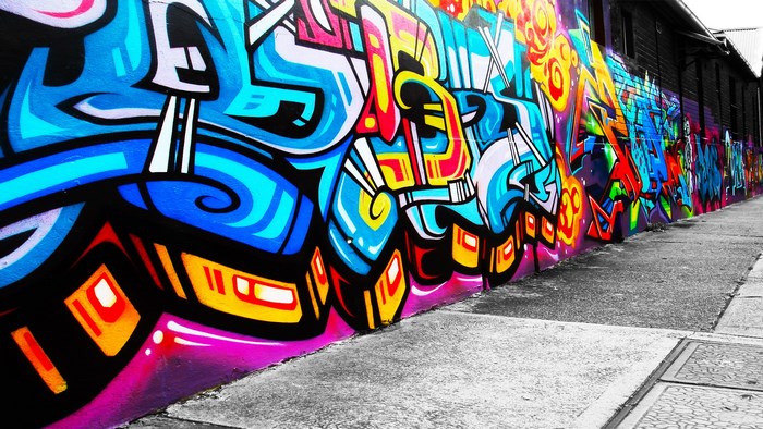 Graffiti on a wall with a sidewalk