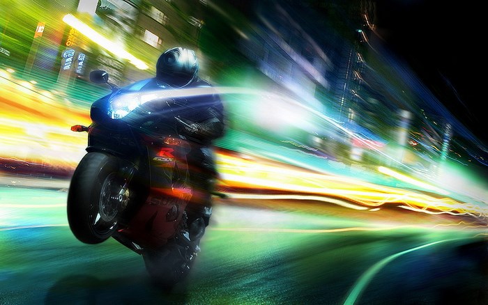 Motorcycle rider doing a wheelie at night