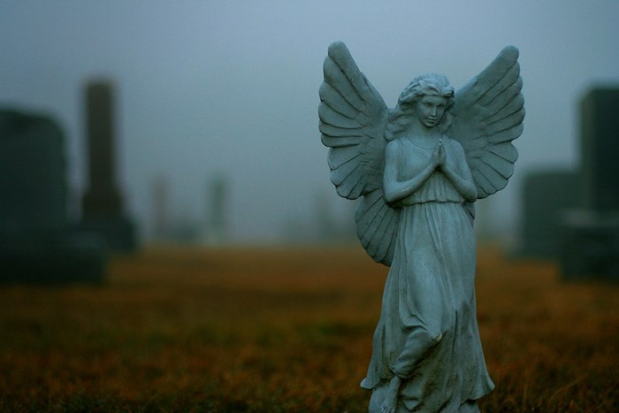 Angel statue in a foggy cemetery