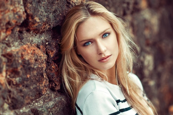 Eva Mikulski Blonde Woman with Blue Eyes Leaning on Rock