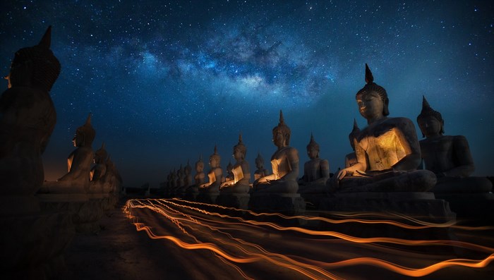 Buddha statues under the Milky Way