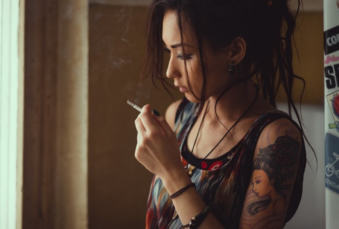 Woman smoking near window