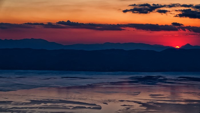 Sunset over mountains and reflective water