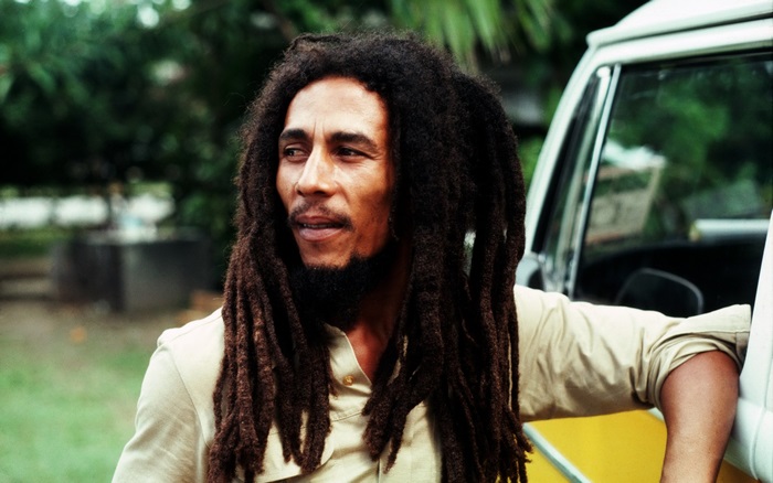 Bob Marley leaning on a vehicle