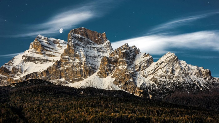 Snow-capped mountains under a starry night sky