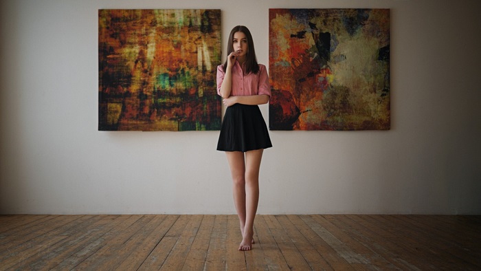 Young woman in pink shirt and black skirt indoors
