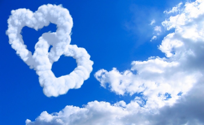 Two heart-shaped clouds in a blue sky