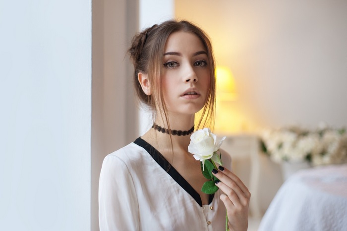 Young Woman Holding White Rose Indoors