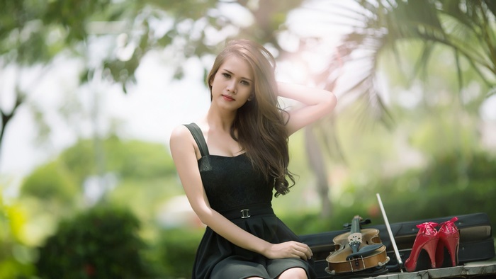 Girl with violin and red heels in park