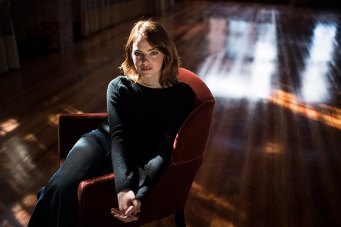 Emma Stone sitting in a chair