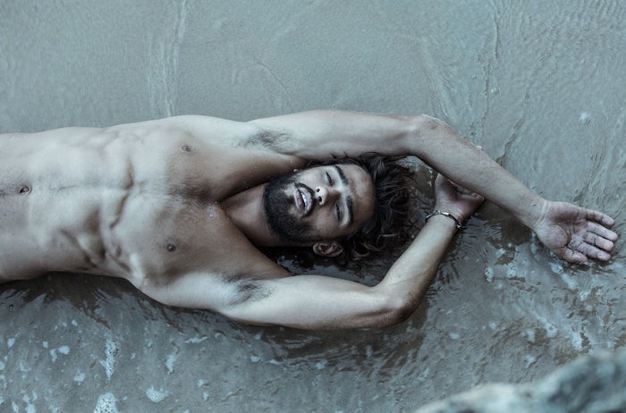 Marlon Teixeira lying on the beach