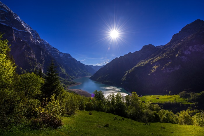 Mountain valley with lake and sun
