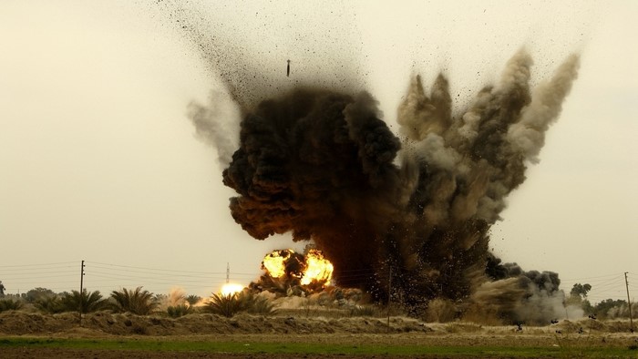 Explosion with debris and fire in a field