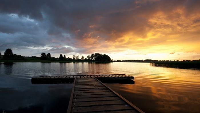 Sunset over a lake with a wooden dock