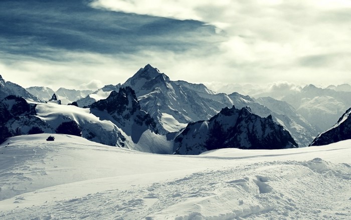 Snowy mountain range under a cloudy sky