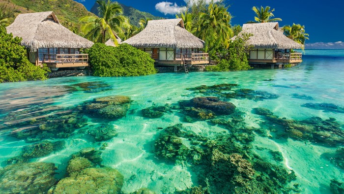 Overwater bungalows in a tropical lagoon with coral reefs
