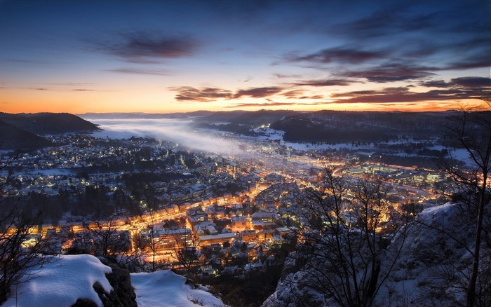 Winter sunset over a German town with mist and snow