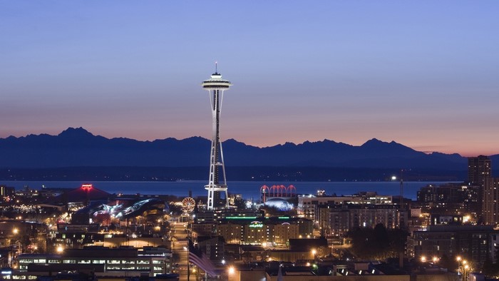 Seattle Space Needle at dusk with mountains