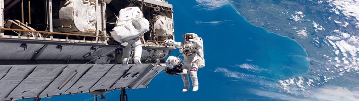 Astronauts performing spacewalk outside International Space Station over New Zealand