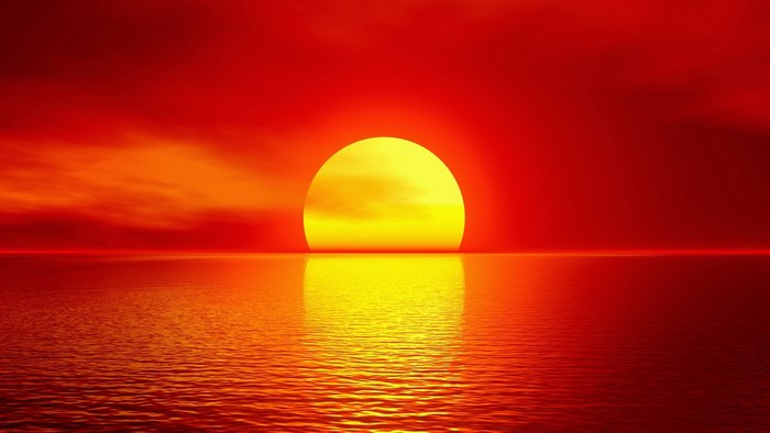 Bright Yellow Sun Setting Over Calm Sea