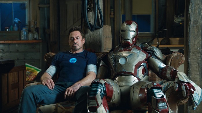 Tony Stark and Iron Man suit sitting on a couch