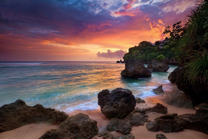 Sunset over a rocky beach in Bali, Indonesia