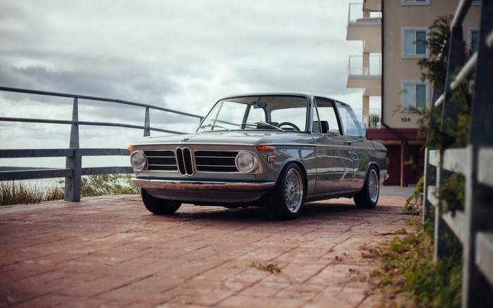 Gray BMW 2002 parked on a brick path