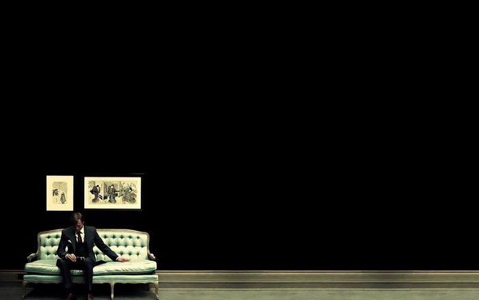 Hannibal Lecter sitting on a couch in a museum