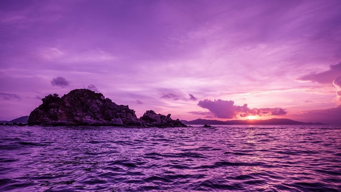 Purple sunset over the sea with an island