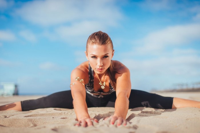 Nicole Mejia doing a split on the beach
