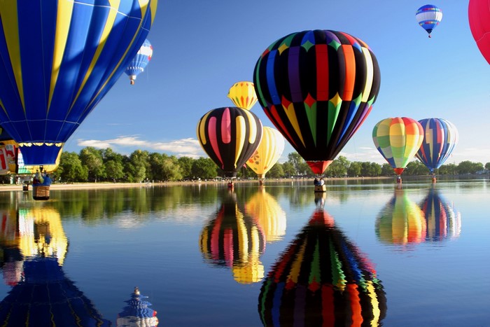 Colorful hot air balloons reflected in a lake