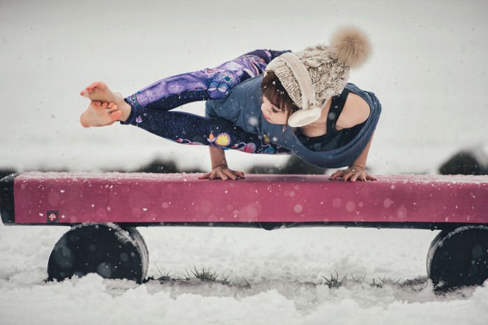 Woman doing yoga in the snow