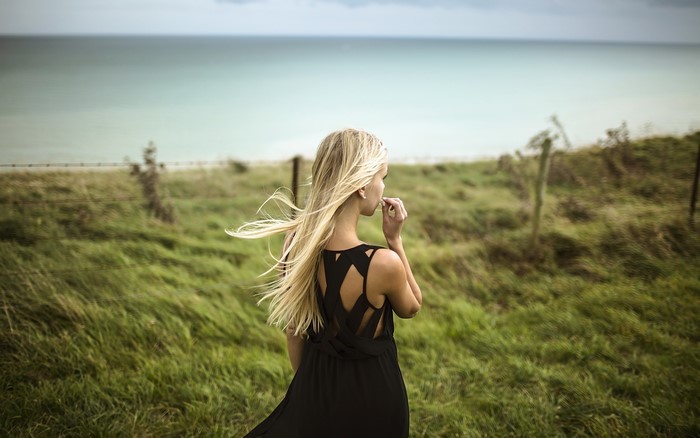 Woman with long blonde hair in a black dress outdoors