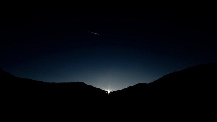 Sunrise over mountains with a shooting star