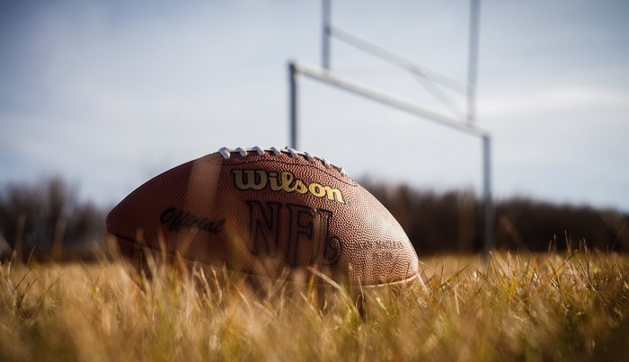 American football on grass with goalposts