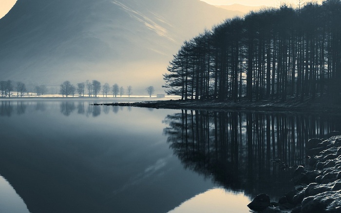 Misty lake with trees and mountains