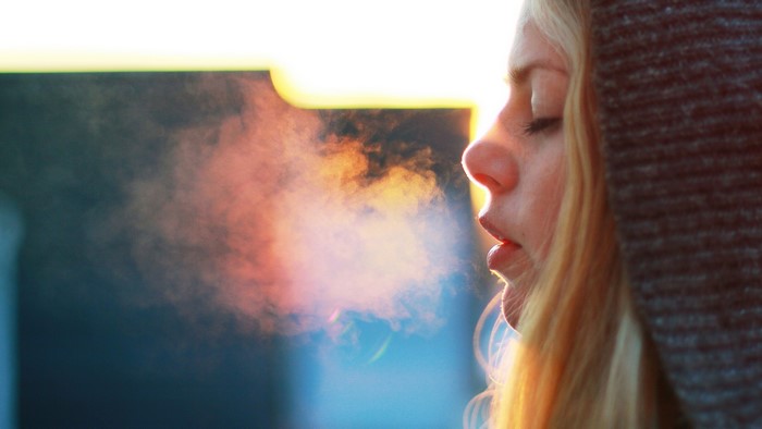 Woman exhaling steam in cold weather