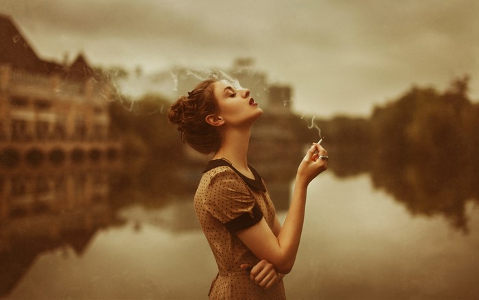 Woman smoking outdoors with sepia tone