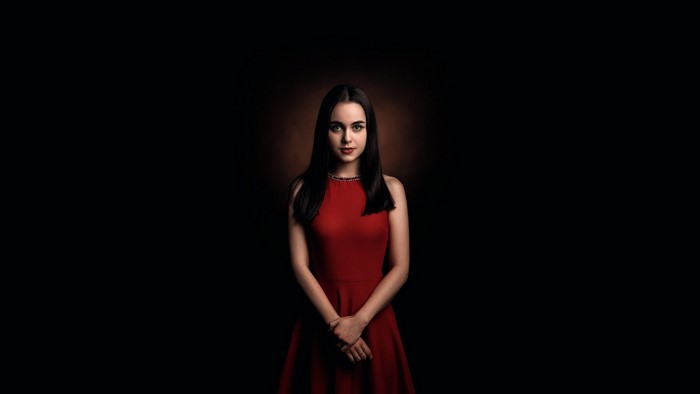 Woman in red dress against dark background