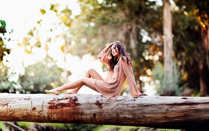 Woman sitting on a log in a forest